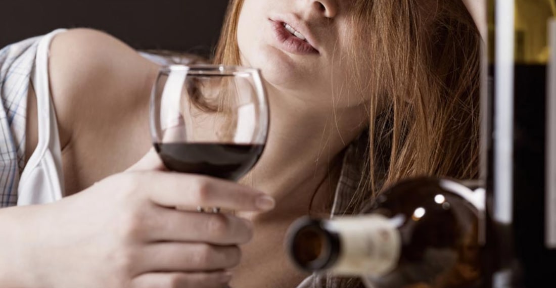 грустная молодая девушка пьет вино 