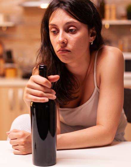 грустная женщина с бутылкой вина