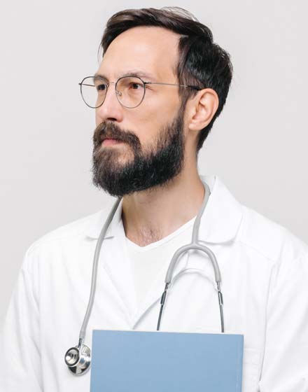 мужчина врач в белом халате смотрит в сторону